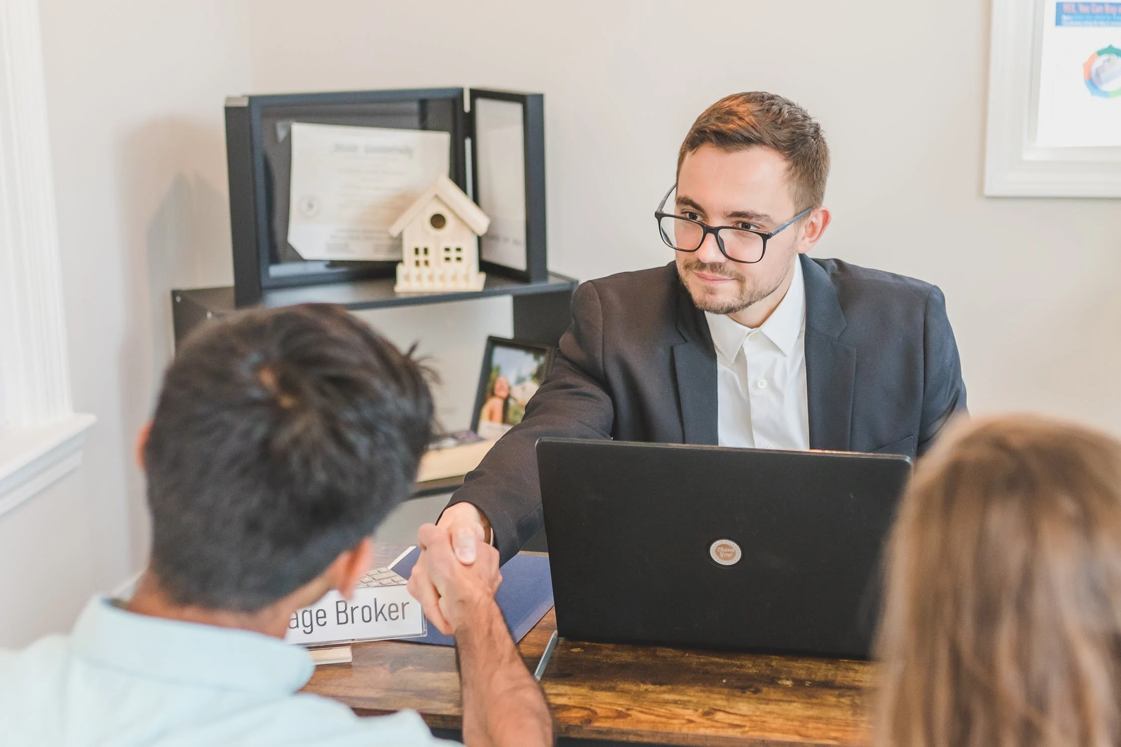 mortgage broker shaking hands with client in office