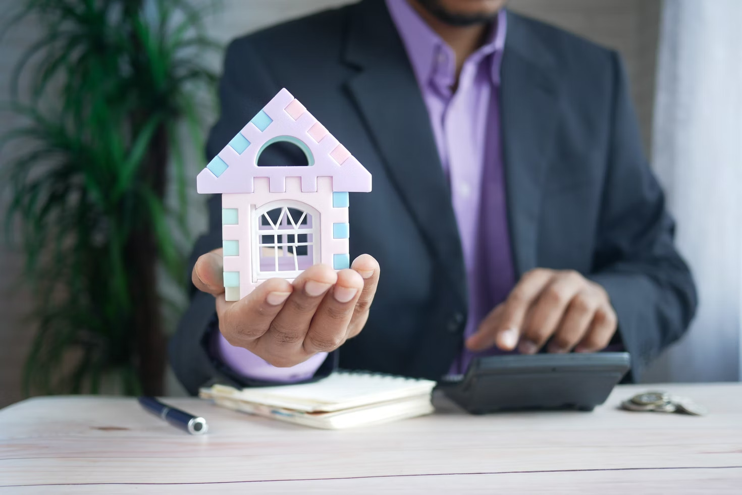 person holding model house